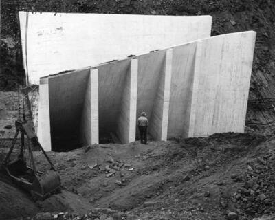 Columbia Basin Project, Irrigation Division, Soap Lake Siphon, Specs. 2411. This photograph shows the left berm of the open outlet transition being excavated to original ground, preparatory to the placing of compacted backfill against the sides of the open outlet transition. Concrete is placed from the beginning of the open inlet transition, Station 510+50 to the end of the last buttress, Station 511+10. When compacted backfill is in place and the slope replaced from Station 511+10 to 511+35 the uniformed bottom and sides will be concreted between the above two stations. The work is being performed by Winston-Utah under Schedule I of the above specifications. H. E. Foss, photographer.