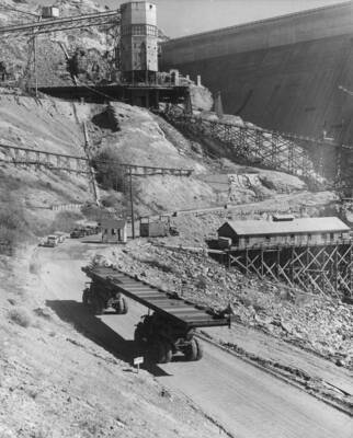 Synchronized trucks handling huge, heavy section of steel roof girder, transporting it to the east powerhouse
