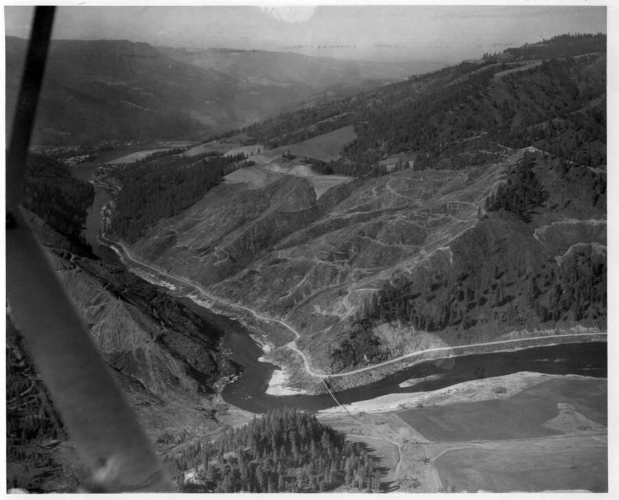 Site before diversion tunnel was started. Clearing work for the dam location has been started. Also, Murphy Bros. have built the access road up to top of dam site on north shore.