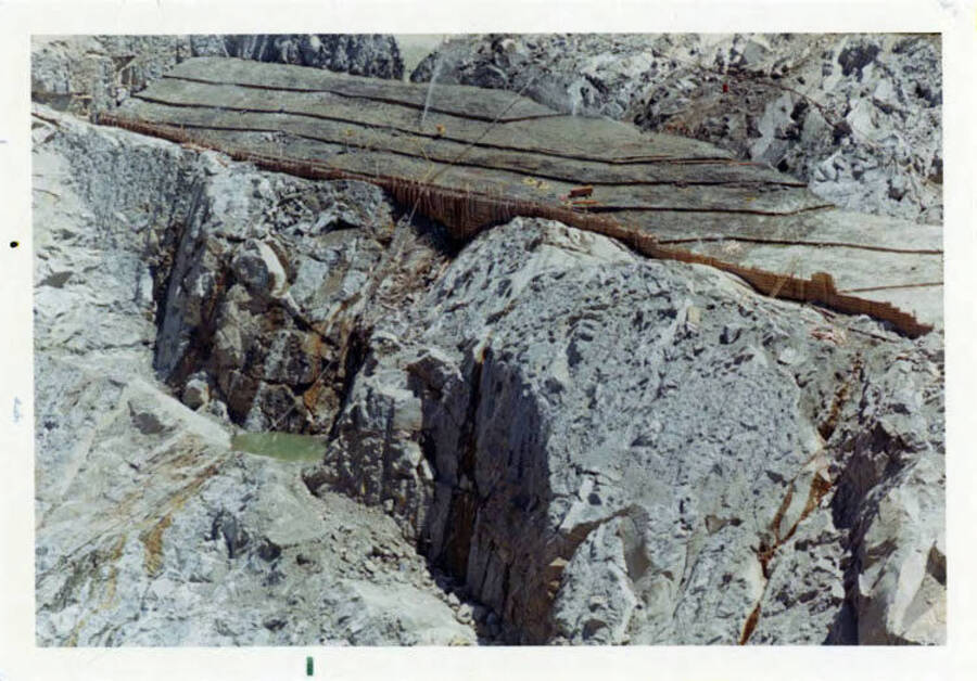 Photograph taken in July.  A closeup of the solid granite that provided the base for the dam, and , of course, the concrete.  Note on reverse reads 'You will see here come faults that had to be routed out and the placement of the concrete in them.  Also note the little patch of water, this had to be routed out to solid base.'
