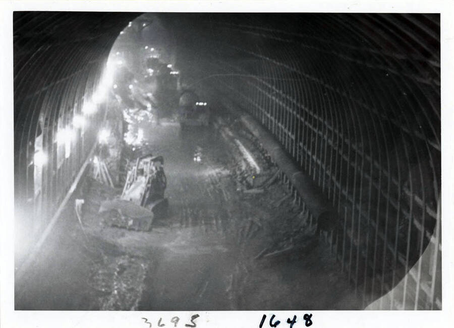 Photograph of inside of the diversion tunnel, which is 40' in diameter, concrete lined.  Here we see the workmen putting up steel reinforcements, for concrete line.