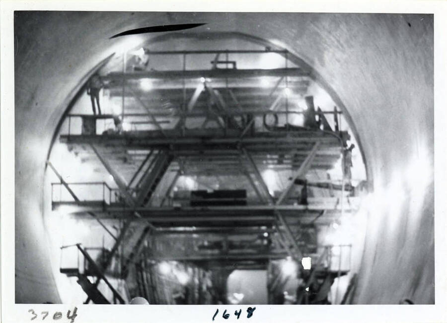 Photograph of the ""Finish Machine"" in the diversion tunnel.  It is round and pushes through the tunnel to do the polish and finish work.  The tunnel is 40' in diameter.