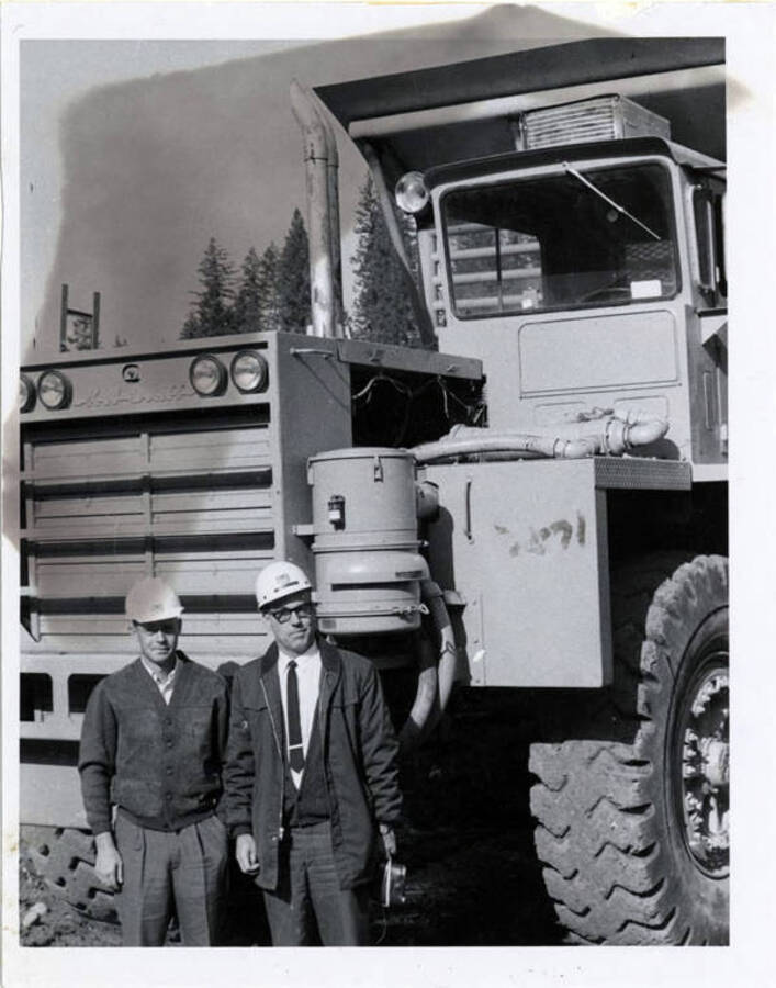 Photograph of Lt. Tom Curtis, so of A.B. Curtis, shown with Don Basgen, Dworshak dam Project Supervisor, in front of a large earth-moving machine.