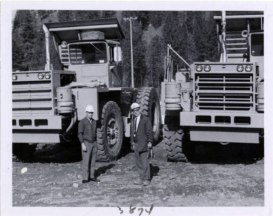 Photograph showing Mr. Curtis' son (Lt.) Tom Curtis with Don Basgen, standing by some large machinery.