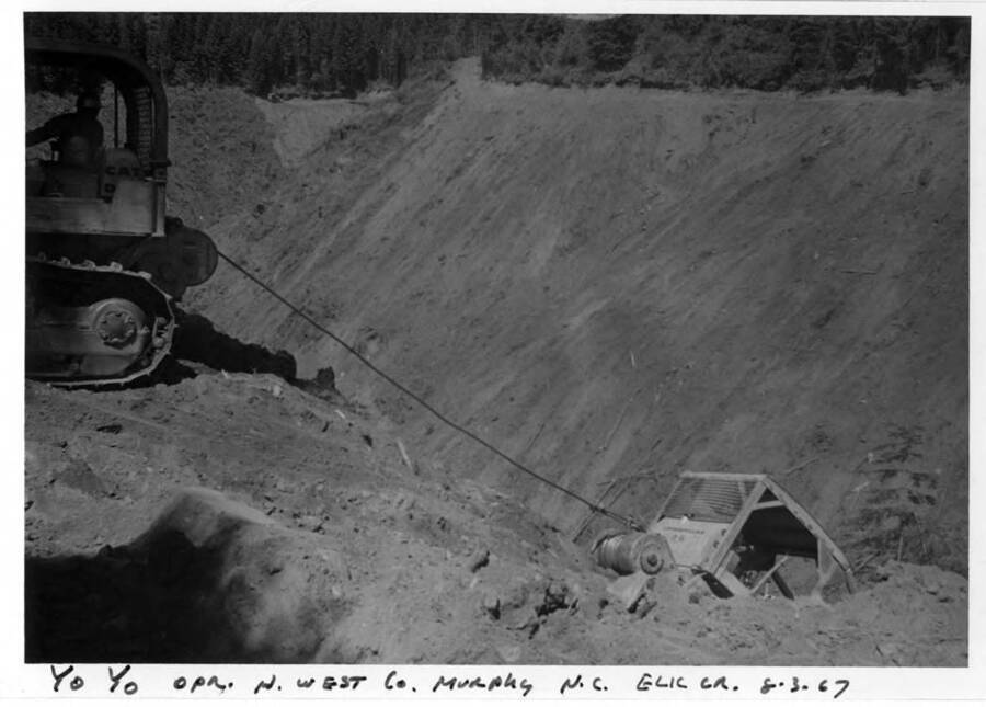 Yo yo work. Note on image: ""Yo Yo opr. N. West Co. Murphy N.C. Elk Cr.  8-3-67"" Note on back: "" Same place, date and operator as #702-705. More yo-yo work and you get the idea better here how the cats are tied together through the winch or drum. Here the cat is being let down.""