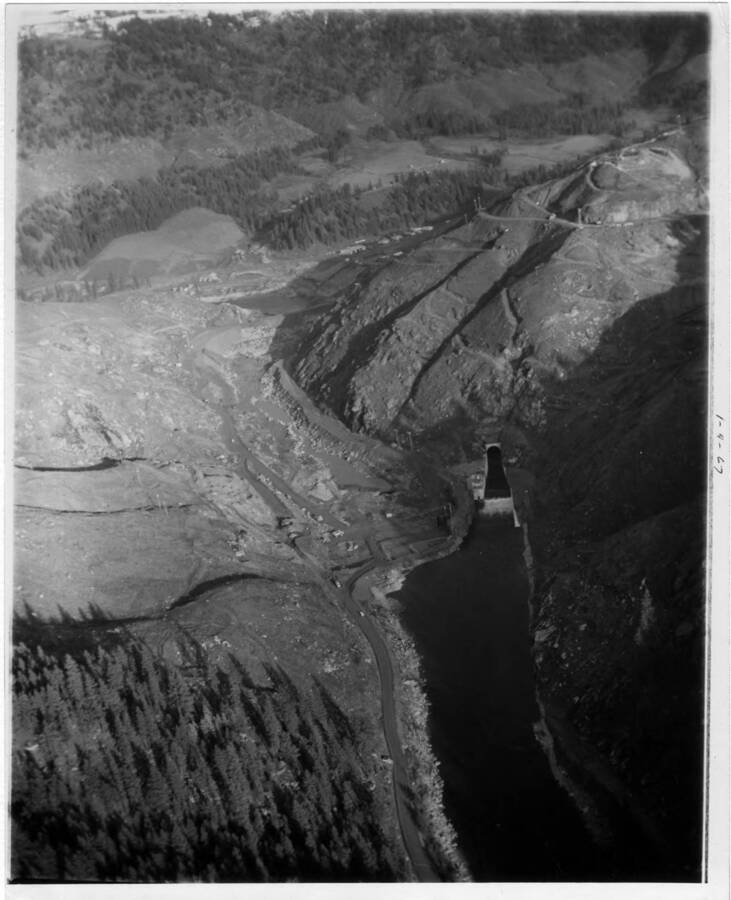 Aerial view taken down-stream from the dam, looking upstream- lower end of diversion tunnel, & the Coffer dam under construction.