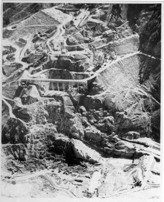Good view of the start of key way construction. Note on back: "The strings of lights across the river are so they could work around the clock, and also note the diversion tunnel and building of the batch plant to run concrete to the job."