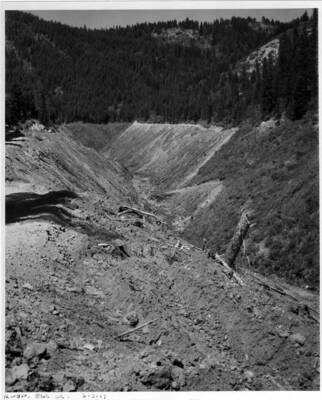 Land clearing operations in the Elk Creek area about 15 miles upstream. Note on back: ""The contractor here had to clean up everything and the work was hard to get to, isolated in some places. You will see small roads built around the top of the clearing - this is one of the things we laid down for access in case of fire on the job (A.B. Curtis)""