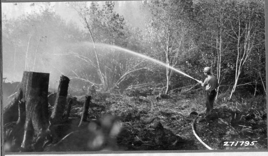 One of two nozzles showing pressure supplied with Pacific pumper, cooling down edges of slash burn. September 1932