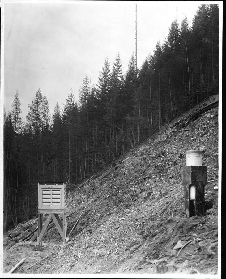 Handwritten on back: "Meteorological Station on North-East Slope. This slope is very thickly timbered with young even aged stand of Douglas Fir, Western White Pine, and Western Larch, with Western Red Cedar & some Hemlock & White Fir in the understory. It was necessary to clear an acre on this situation in order to make room for the instruments and so as to place the instruments in an exposed situation comparable with those other instruments on southwest slope and Benton Flat. Situation typical of White Pine Type."