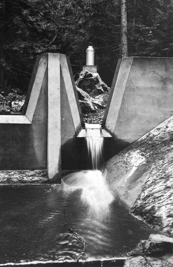 Back of photo reads: "Friez recording precipitation gage mounted on rock above Benton Creek gaging dam as seen through weir #2 of dam. November 20, 1939. Depth of water at weir crest = 0.143 feet. Volume of water discharged at this time = 0.186 cu. Ft. per second. f-32, 2 seconds, distance 30 ft."