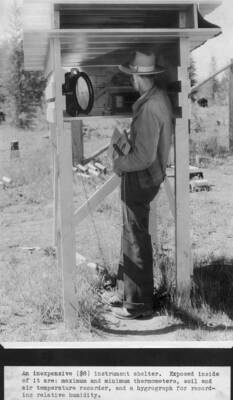 An inexpensive ($8) instrument shelter. Exposed inside of it are: maximum and minimum thermometers, soil and air temperature recorder, and a hygrograph for recording relative humidity. Joy Armstrong.