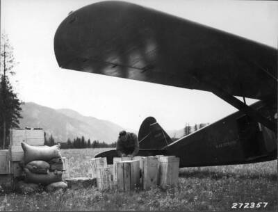 Checking supplies unloaded from plane at Bartlett Creek Landing field.