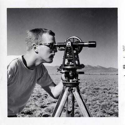 Iain Baxter using surveying transit.