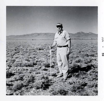 Professor Larrison holding line marking rod while Baxter sights it into correct position.