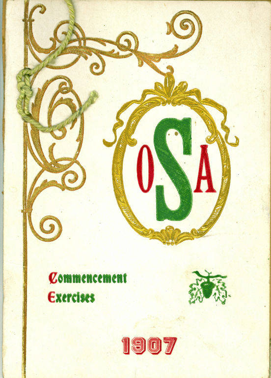 A decorative card with an ornate gold border design. In the center, there is a large gold-framed oval with the letters "OSA" inside, colored red and green. Below, the text "Commencement Exercises" is written in red and green. At the bottom, the year "1907" is displayed in red. A green cord is tied to the left side.