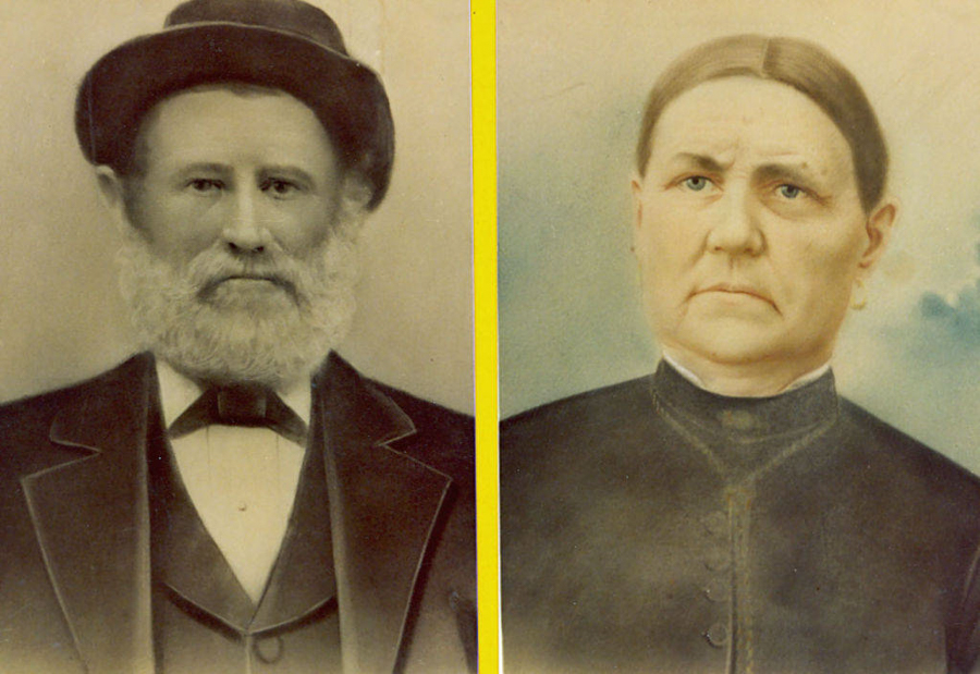 A man with a beard wearing a bow tie and hat next to a woman with her hair parted in the center, wearing a high-collared dress.