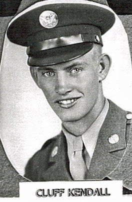 A man in a military uniform is smiling at the camera. He is wearing a peaked cap with an emblem on it and a uniform with visible buttons and insignia. Below the image, there is a label with the text "CLUFF KENDALL."
