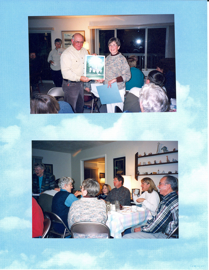 Top image: A man and a woman stand together holding a framed picture. They are in a room with several people seated and some standing. A window with curtains is visible in the background.

Bottom image: A group of people are sitting around a table having a meal. The table is covered with a checkered tablecloth. Shelves with various items are visible on the wall. There is a person standing and holding something near the table.