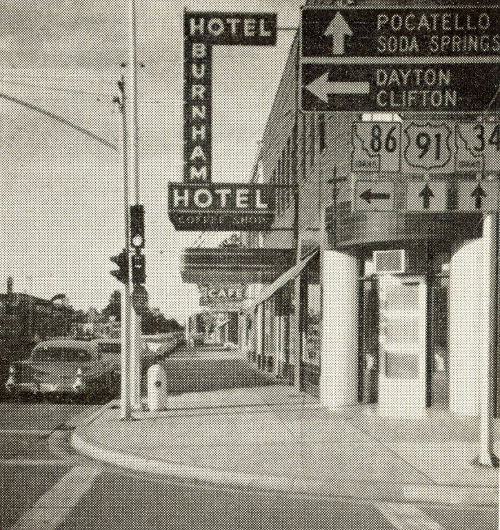 Street view featuring signs for Hotel Burnham and a cafe. Directional signs point to Pocatello, Soda Springs, Dayton, and Clifton. Traffic lights and a parked car are visible. Road signs display numbers 86, 91, and 34.