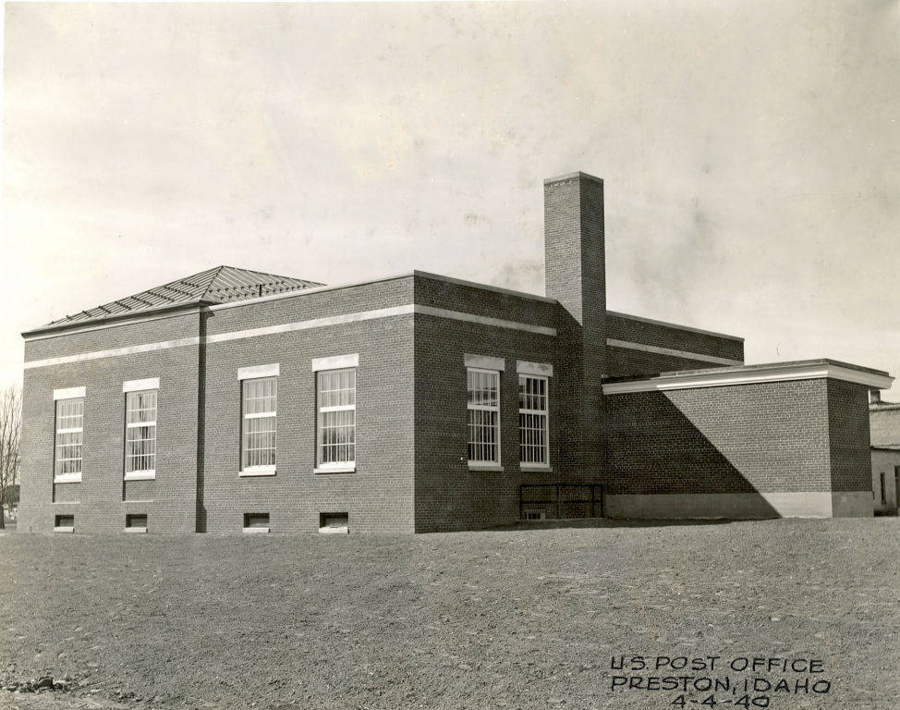 A brick building with several tall windows and a chimney. The structure appears to be a rectangular shape with a flat roof. There is text in the corner that reads, "U.S. Post Office, Preston, Idaho, 4-4-49."