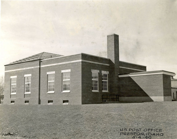 A brick building with several tall windows and a chimney. The structure appears to be a rectangular shape with a flat roof. There is text in the corner that reads, "U.S. Post Office, Preston, Idaho, 4-4-49."