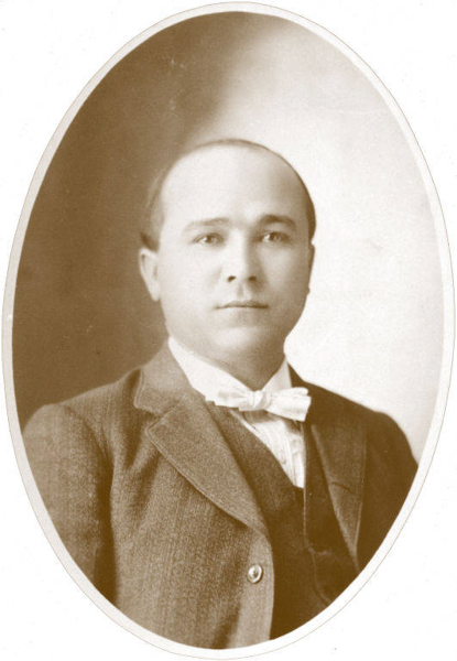 A man wearing a suit, a vest, and a bow tie is looking directly at the camera. The portrait is oval-shaped.