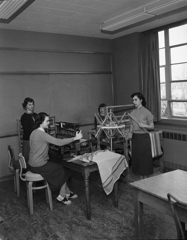 Four students operating weaving looms.