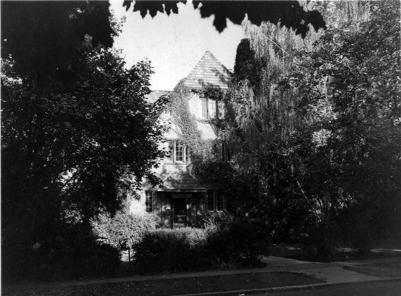 A photograph of the Pi Beta Phi sorority house through foliage.