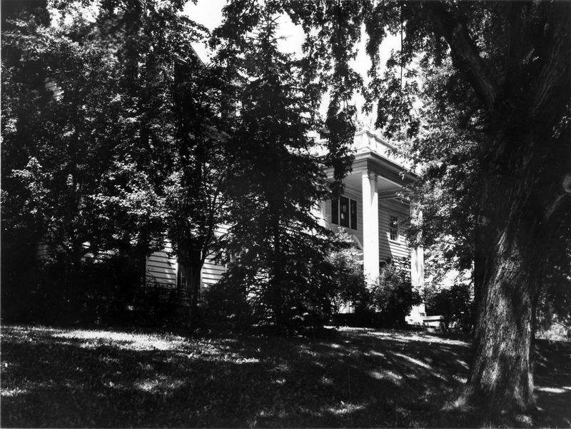 A photograph of Kappa Gamma sorority house through the foliage.