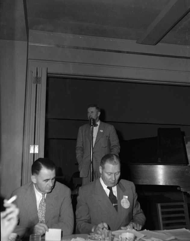 An unidentified man speaking at the University of Idaho 1927 Class reunion. Two men can be seen dining in the foreground.