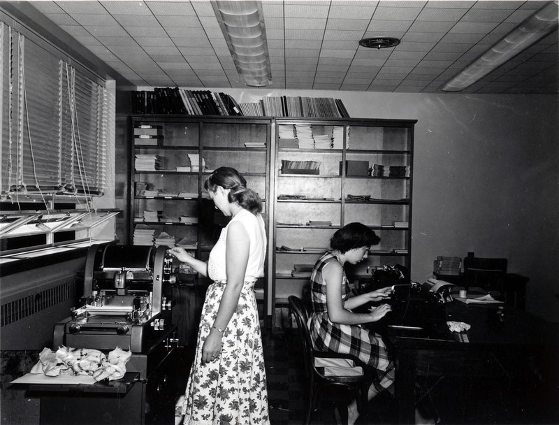 A photograph of the Argonaut office with one women at a typewriter and the other operating a newspaper printing press.