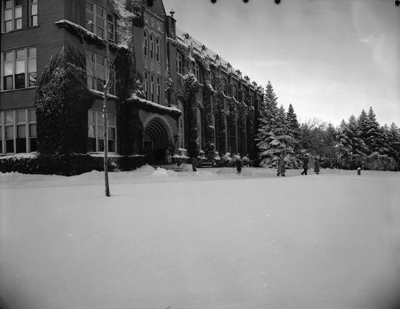 A photograph of the Administration building in winter, people can be seen walking away from the entrance.