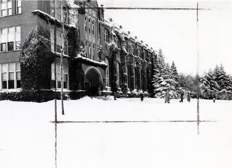 A photograph of the Administration building in winter, people can be seen walking away from the entrance.
