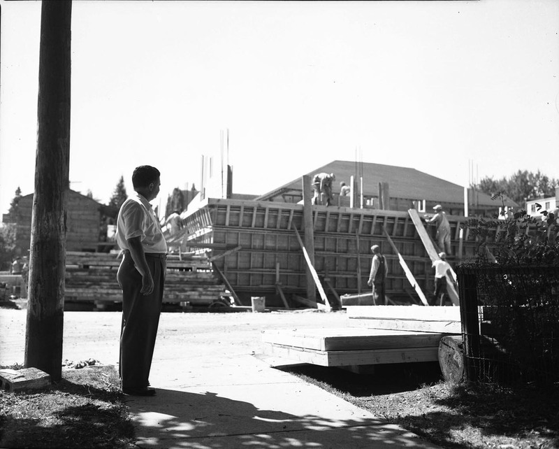 A photograph of a man watching the construction crew build the addition to the Student Union Building (1936).