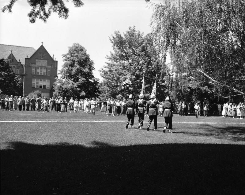 ROTC members on campus with a large crowd of students.