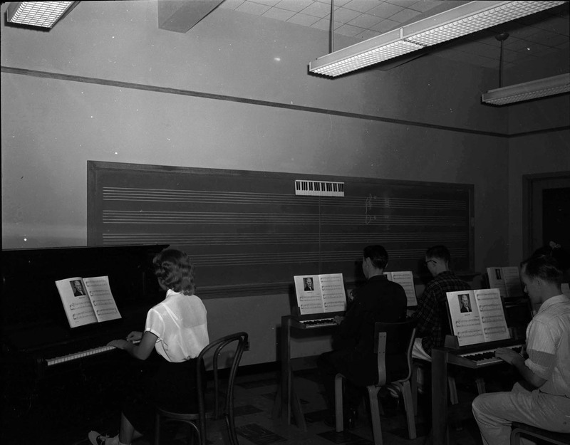 Students practicing piano in class.