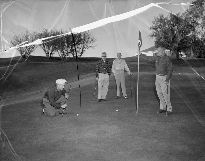 A group of unidentified men golfing on the University golf course.