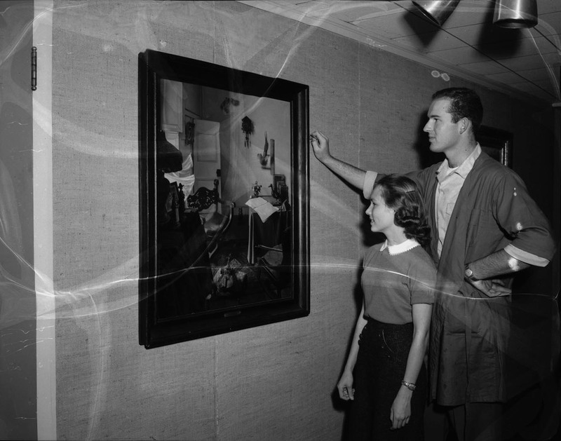 Students Roy Ehlers and Anne Kirkwood inspecting IBM painting "Home of the Artist."