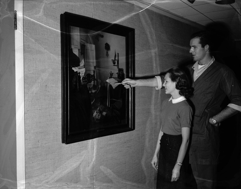 Students Roy Ehlers and Anne Kirkwood inspecting IBM painting "Home of the Artist."