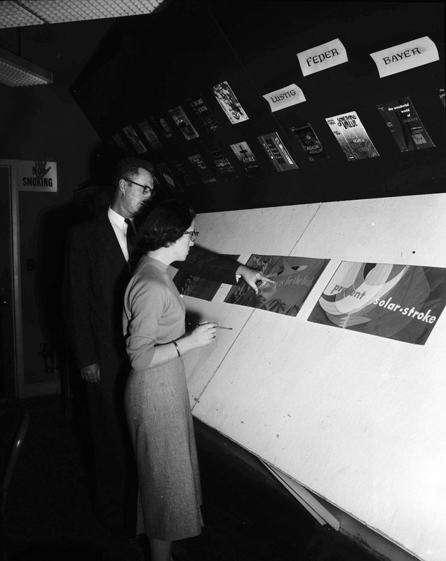 Artist Alf Dunn looking at advertisements with a commercial art student at the University of Idaho.