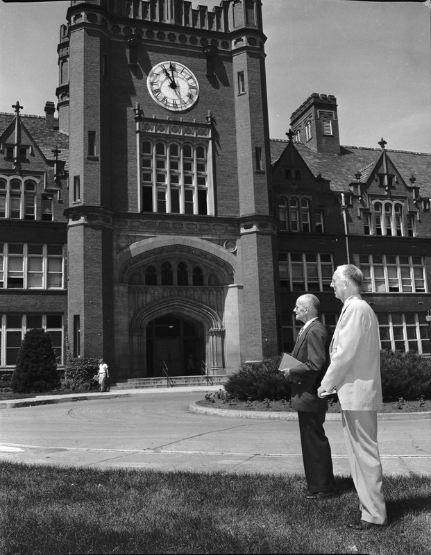 Retiring Professors Claude W. Ashby and J. Hugo Johnson standing in front of the Administration Building.