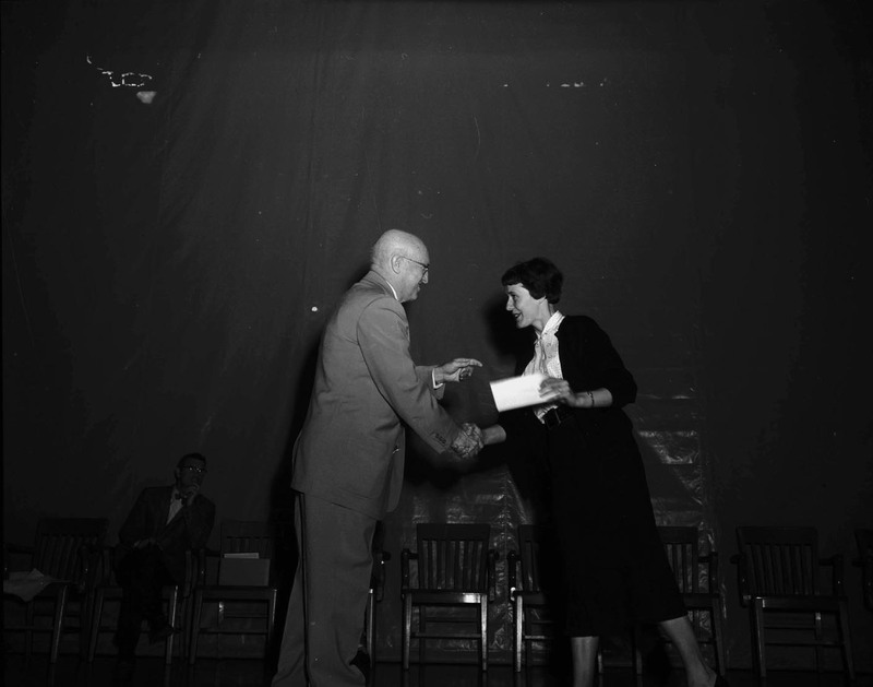 Eula Gray receiving an award from Chris Hansen at commencement.