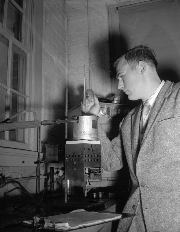 Francis E. Keller, Boise Petroleum scholar,  checking distillation flask in College of Engineering asphalt laboratory.