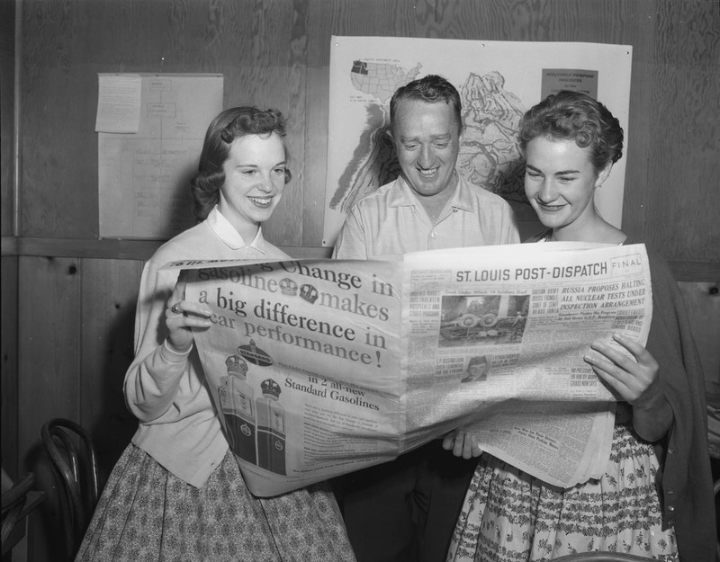 Dr. Granville, Dr. Price, and Sharon McDonough reading the paper in a journalism workshop.