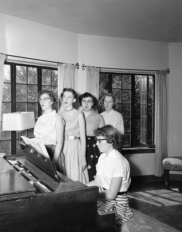 Women singing around a piano at Lewis-Clark State College.