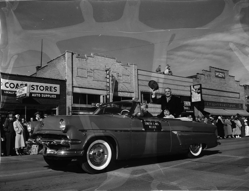 Idaho Senator Welker and his wife, Gladys Welker, in a automobile during the homecoming parade in downtown Moscow.