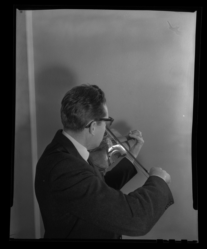 A profile from behind of University of Idaho Professor Leroy Bauer with his violin.