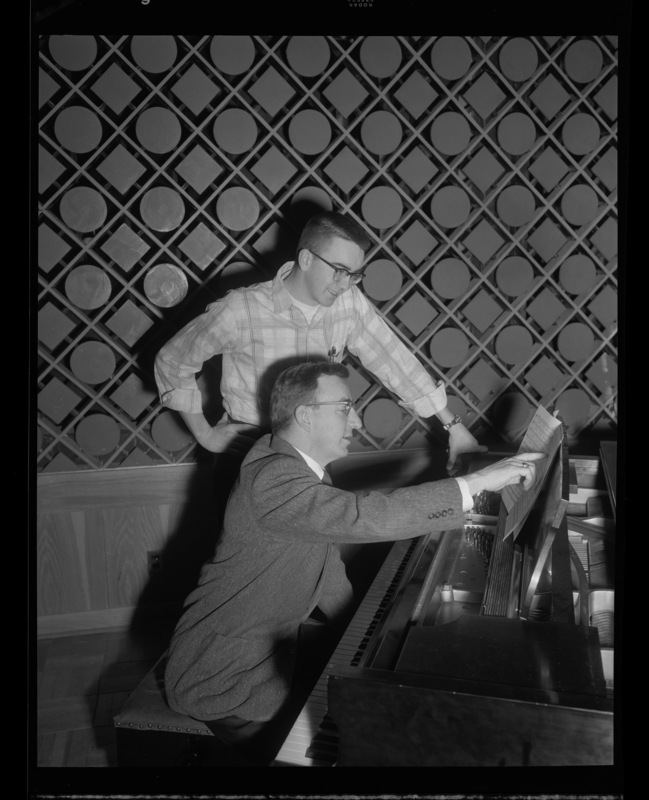 Glen Lockery sits at a piano instructing a member of the Vandaleers, Neil Sampson.