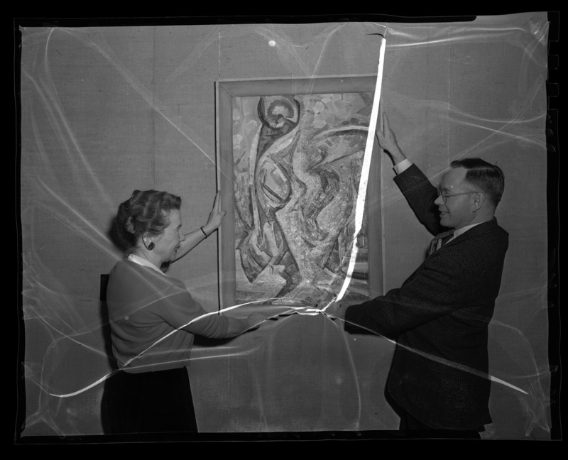 Agnes Schuldt, Professor of Music, and John McMullen hanging picture for the first art festival at University of Idaho, held March 10-14, 1959.